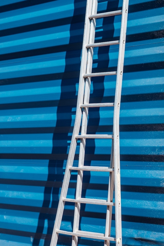 Recruiting Employees Ladder Leaning Against Striped Wall