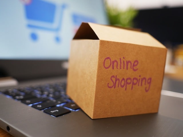 Small box sitting on laptop with “online shopping” written on it