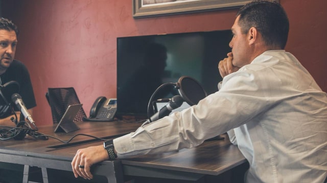 Two men at a desk recording a podcast