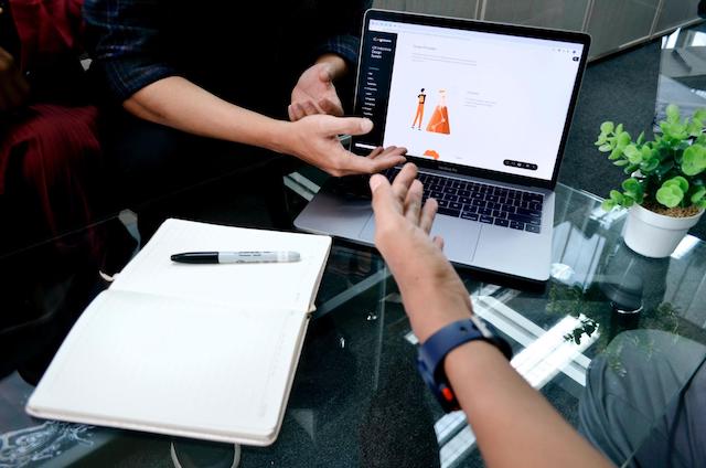 Two people discussing a website on a laptop