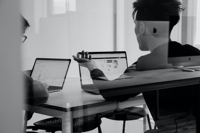 Two people talking at a desk