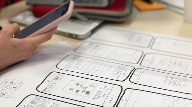 UX designer with phone and sketches