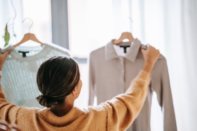 Woman looking at two different blouses