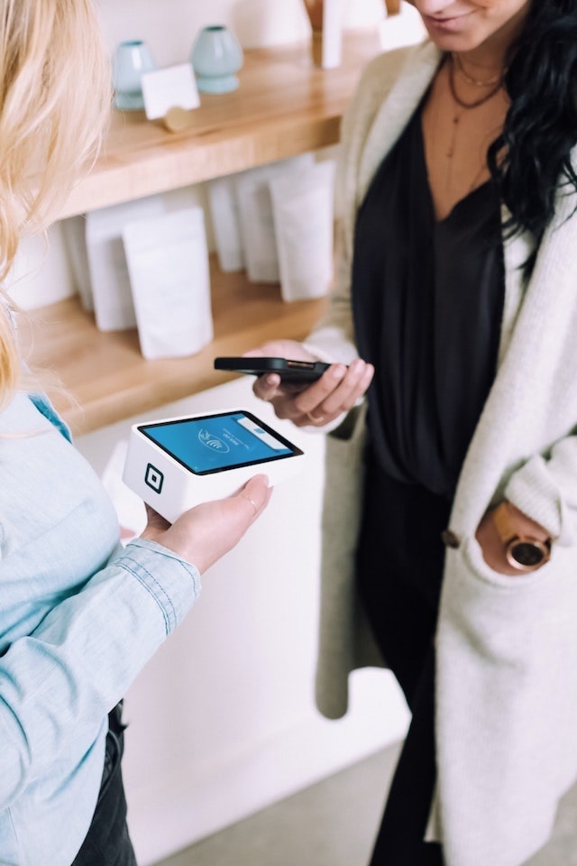 Woman using smartphone for contactless payment