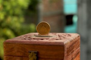 Wooden cash box with a Rupee on top