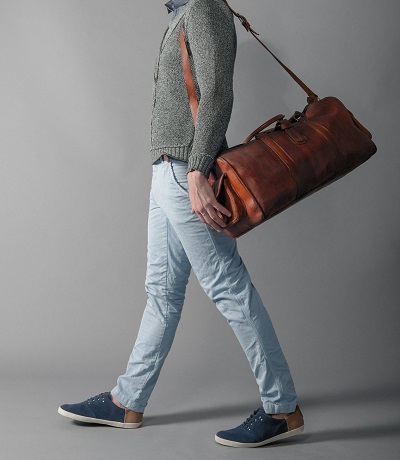 hombre modelando una bolsa de piel