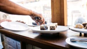 Person Picking Up Pastry with Tongs