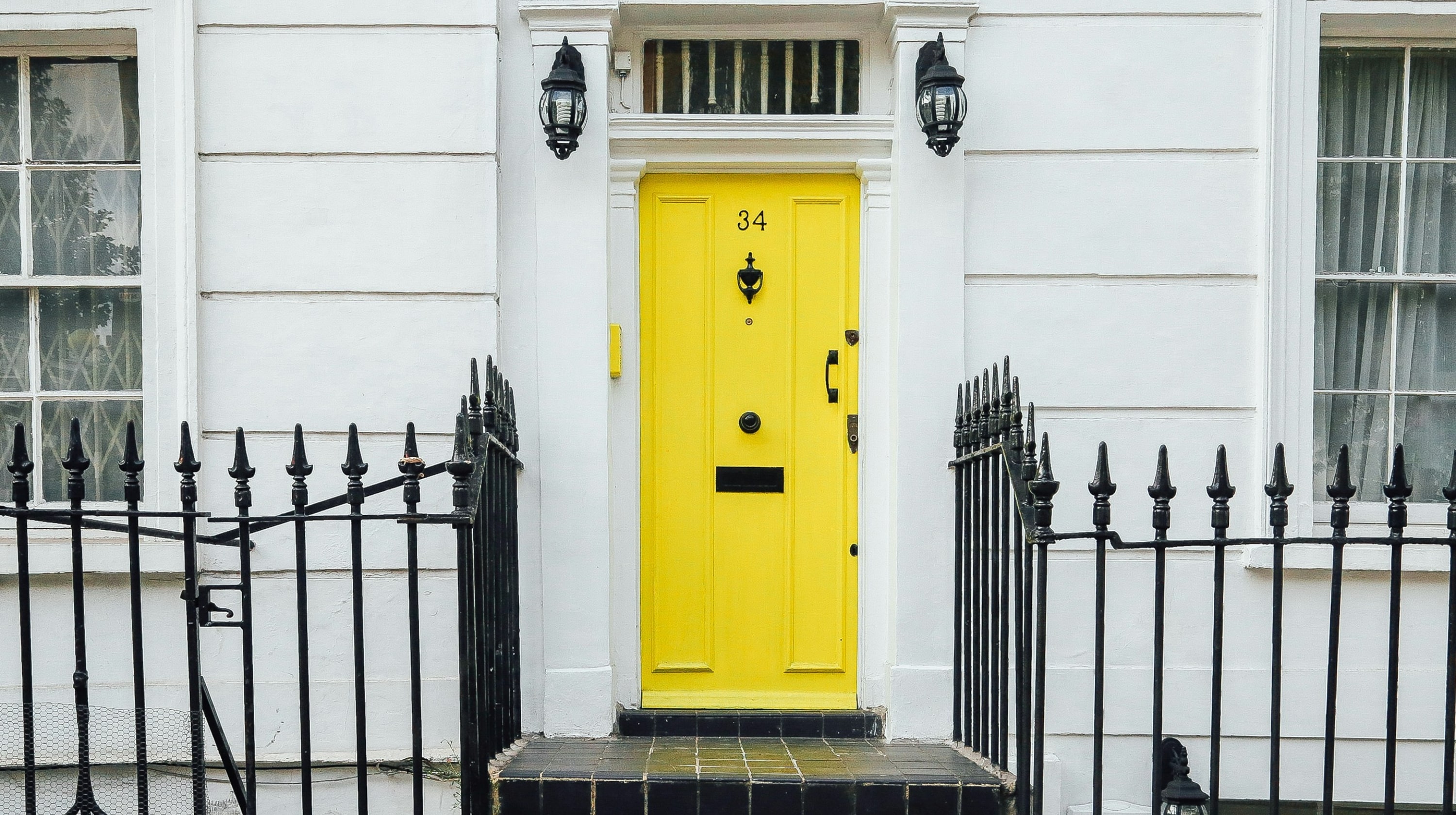 Bright yellow front door with the number 34