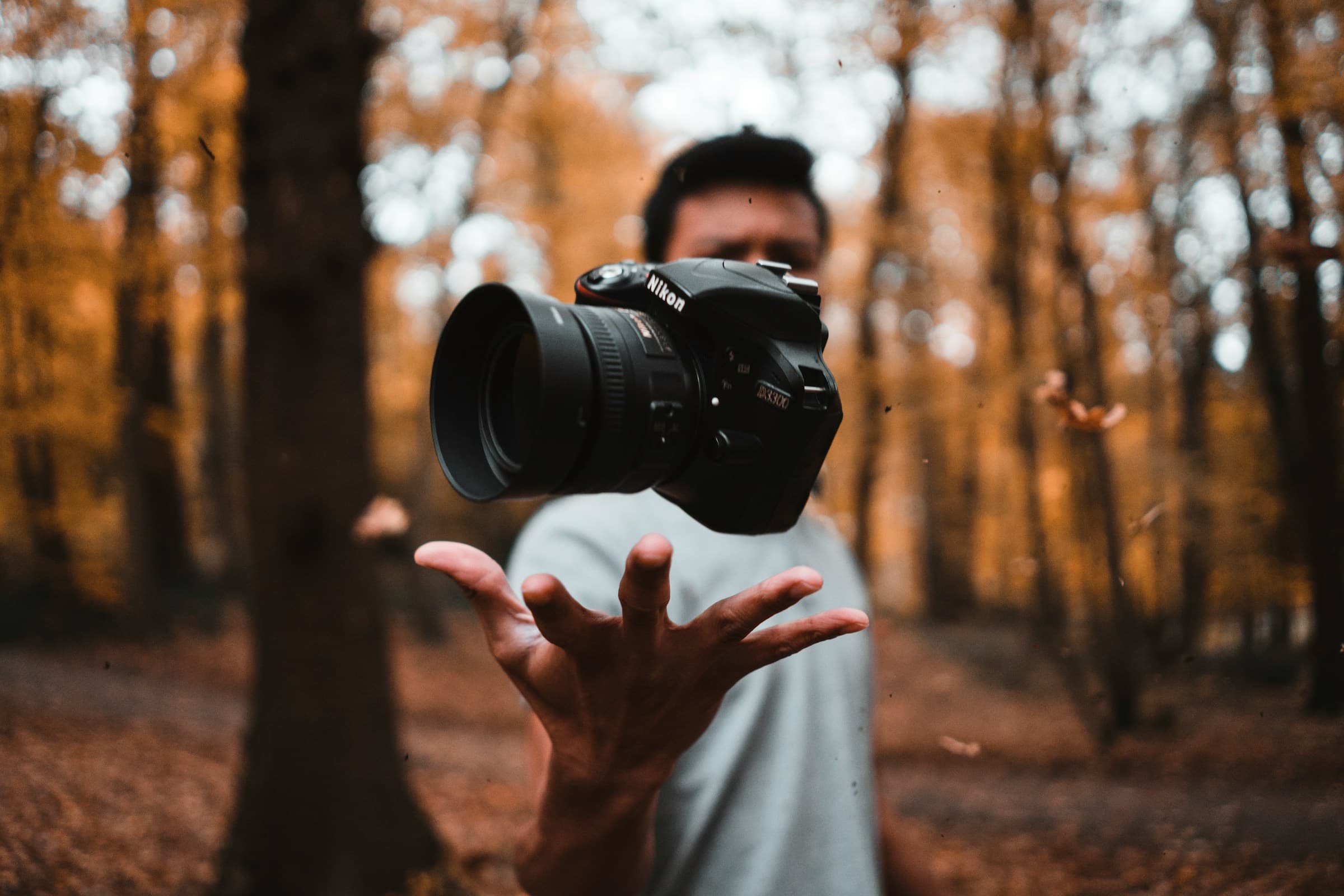 Man tossing a Nikon camera in the air