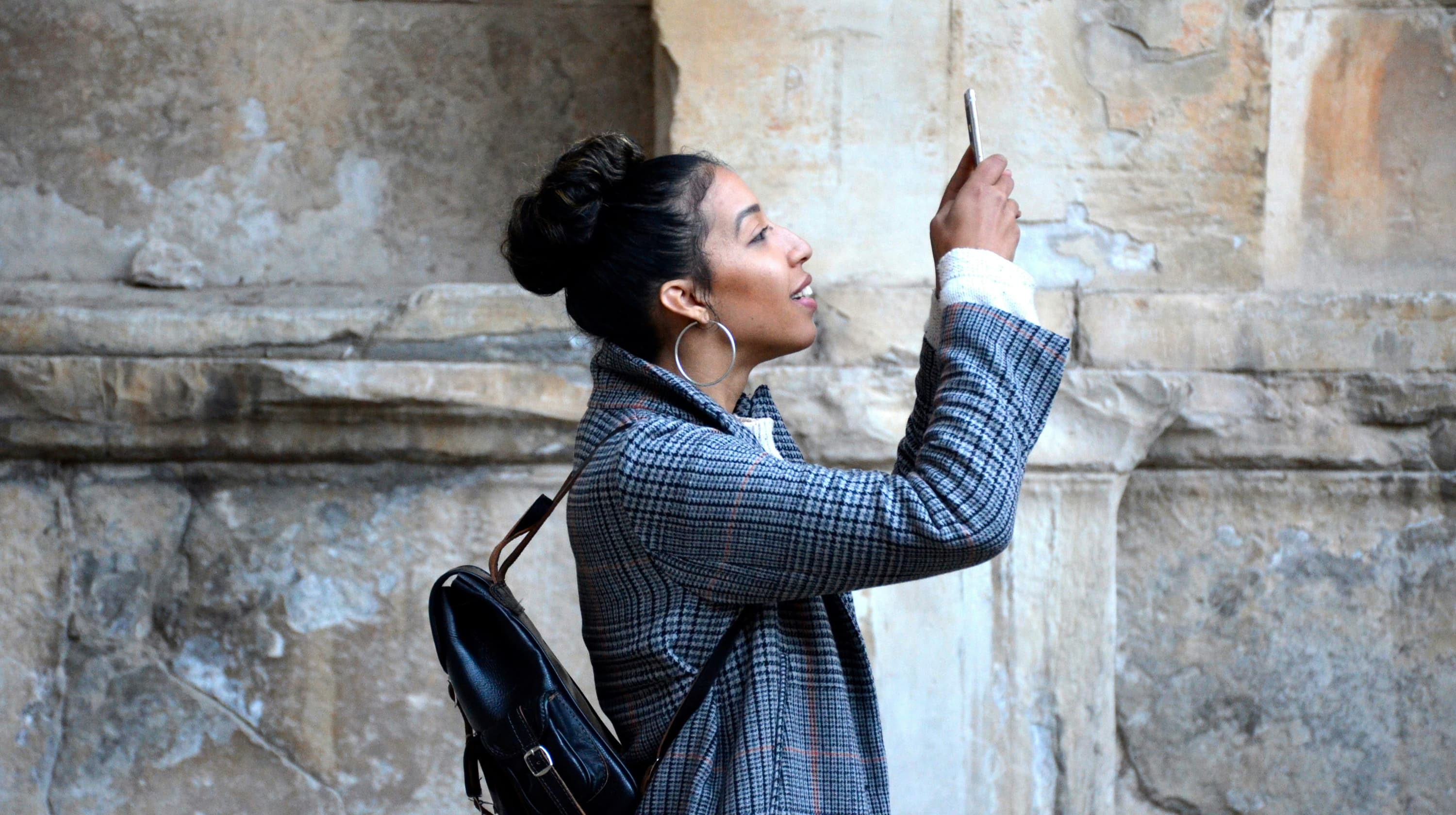 Woman taking a selfie next to a building