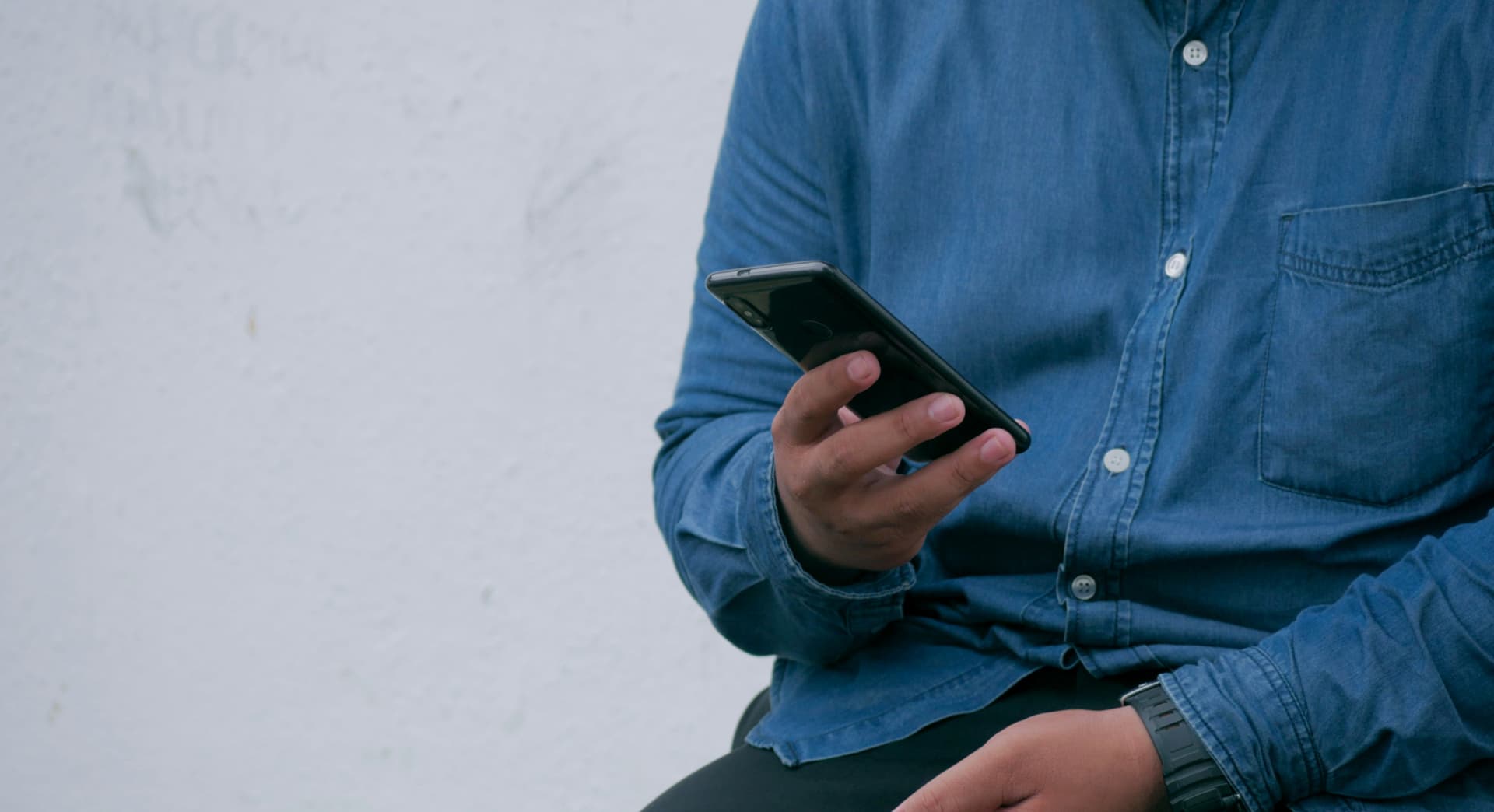 Man sitting and looking at a smartphone