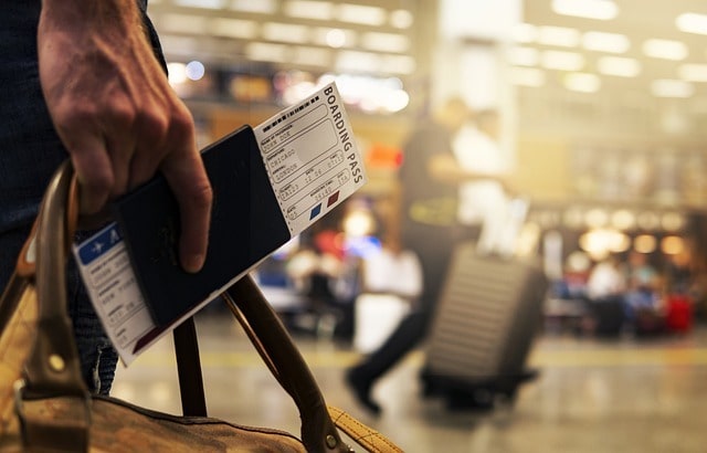 Traveller holding a boarding pass and carry on