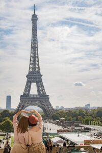 Two women looking up at the Eiffel Tower