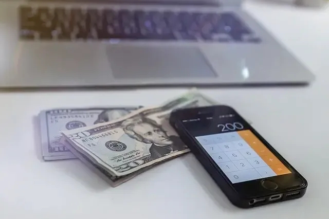 A Mobile Phone Sits atop Two Stacks of $20 Bills