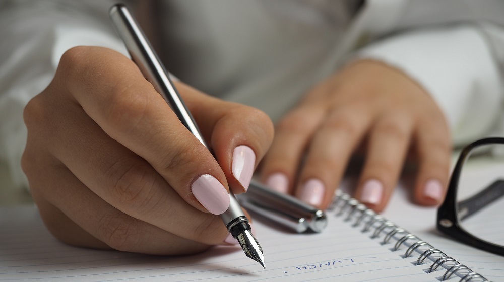 Woman Making A List Illustrating How To Do A SWOT Analysis