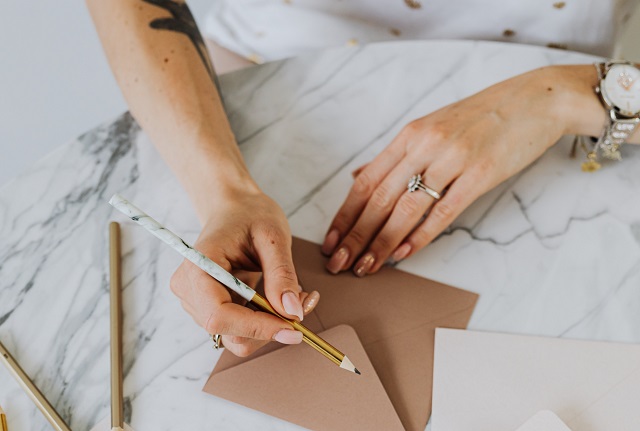 Woman writing letters on marble table