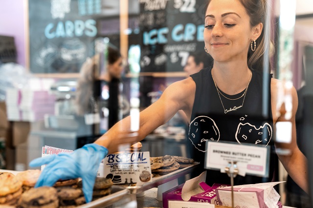 Lauren stacking cookies in the display case