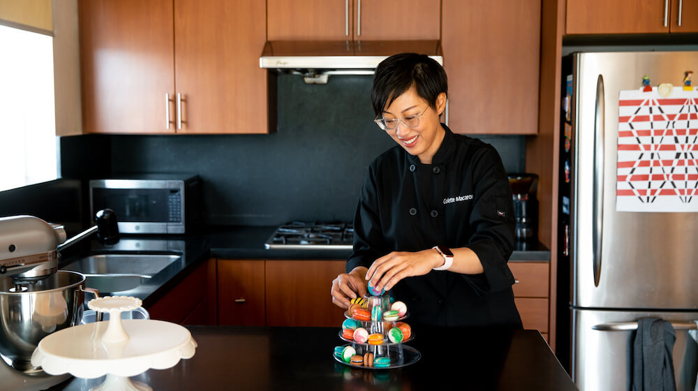 Anita Lee displaying macarons in kitchen