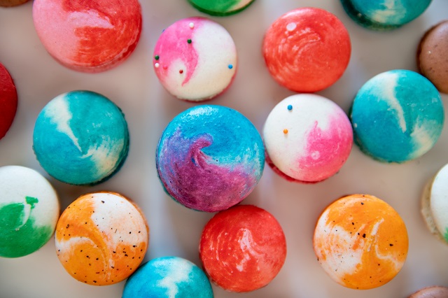 Colorful macarons spread across a table]