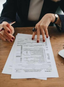 Woman holding pen and reviewing tax documen