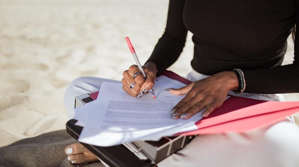 woman working on beach with contracts