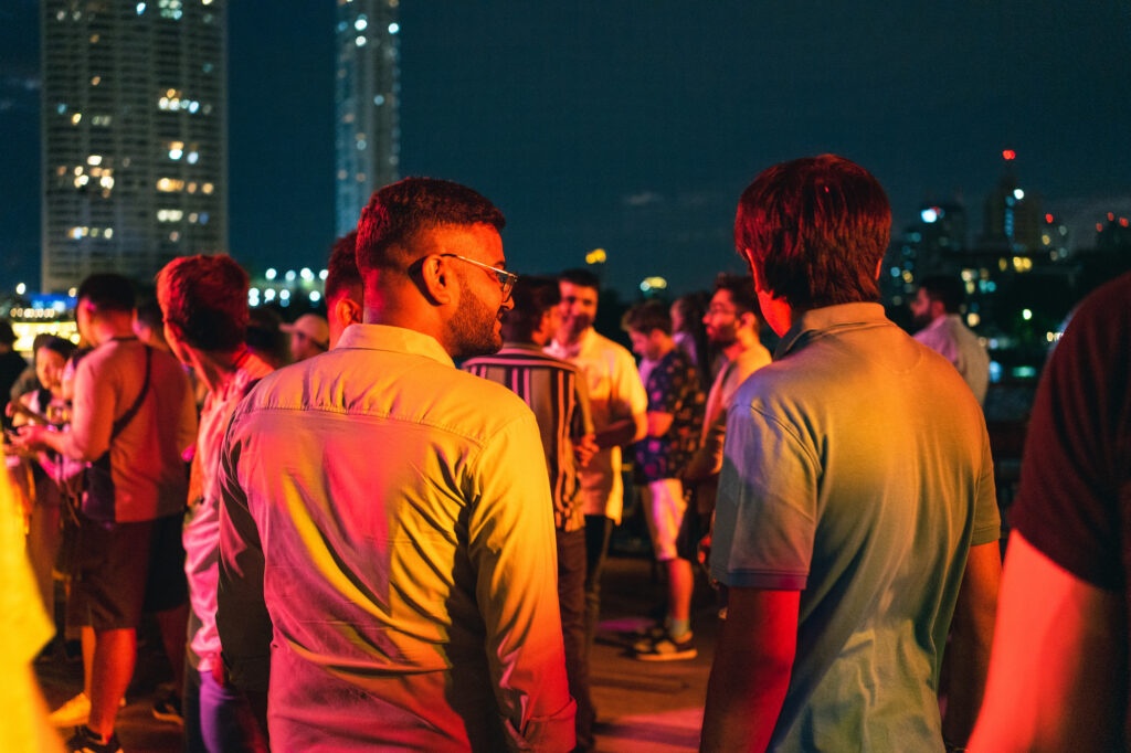 WordCamp Asia people at the GoDaddy boat party from behind with a skyline view