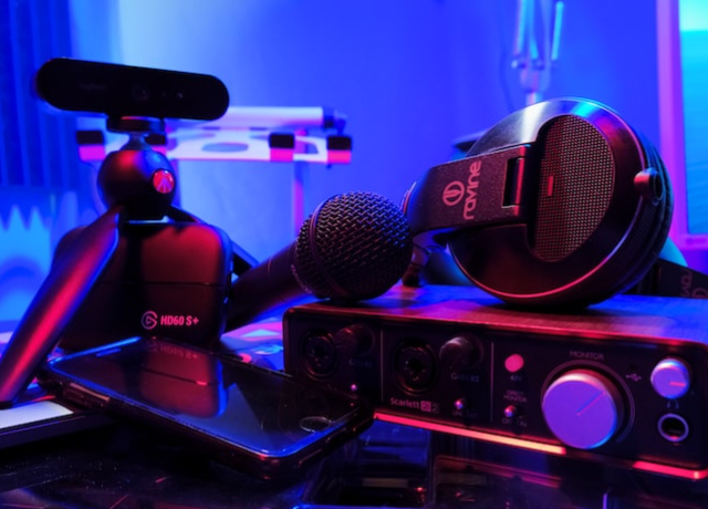 Pile of audio equipment in a room lit by blue LED lights