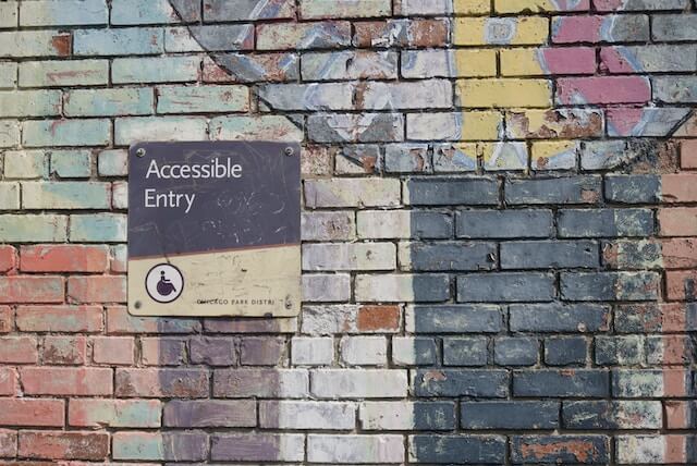 Accessibility sign on a colorful brick wall(2)