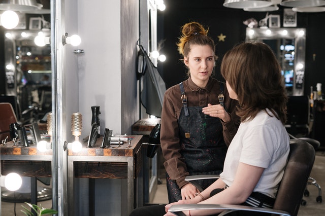 Two women talking to each other in a hair salon