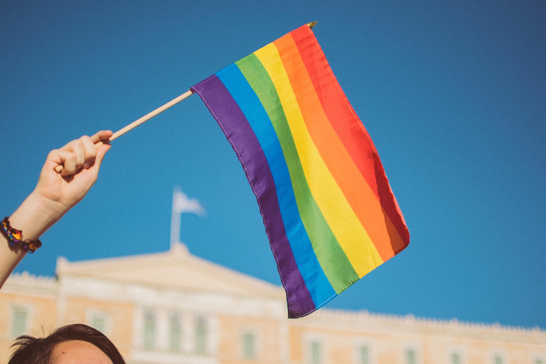 A person holding a rainbow flag