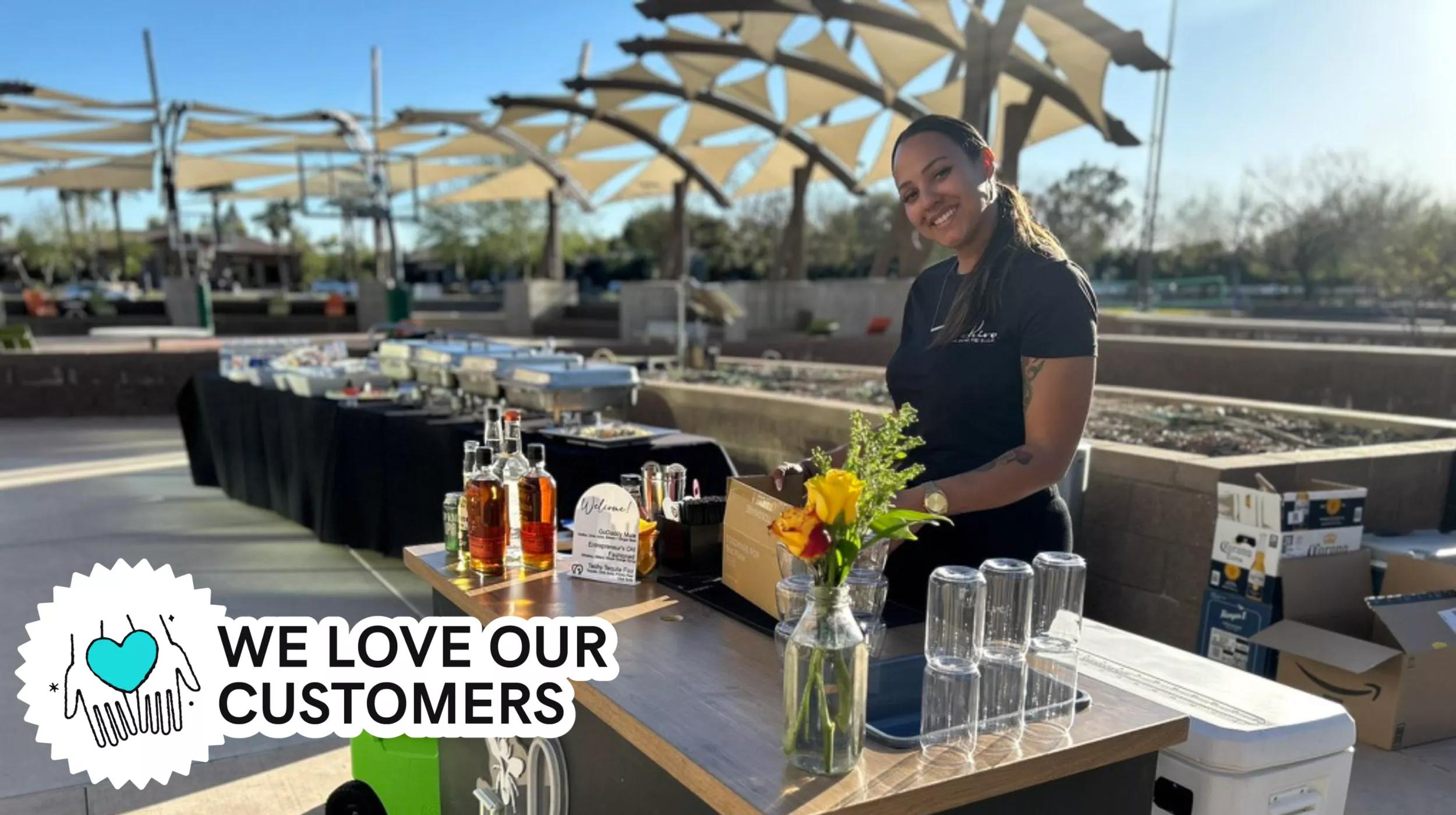 Bridgette Baldwin, owner of The Hive, standing behind a mobile cocktail bar at the GoDaddy Tempe campus in Arizona.