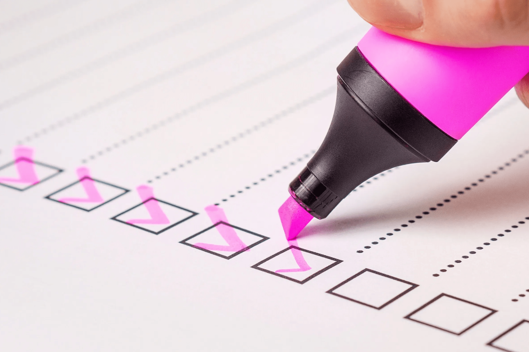 Pink highlighter checking off boxes on a checklist.