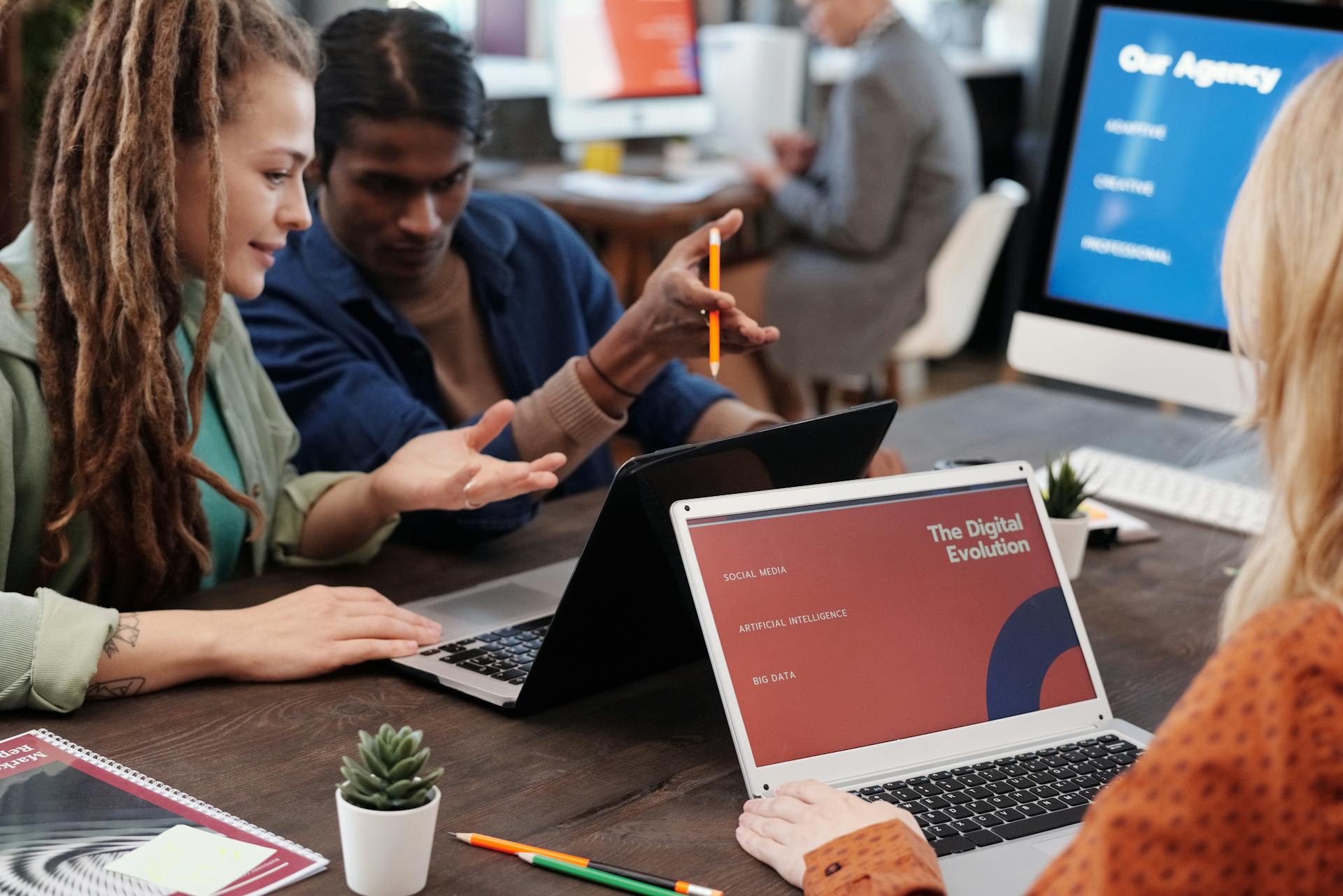 a group of people sitting at a table looking at a laptop