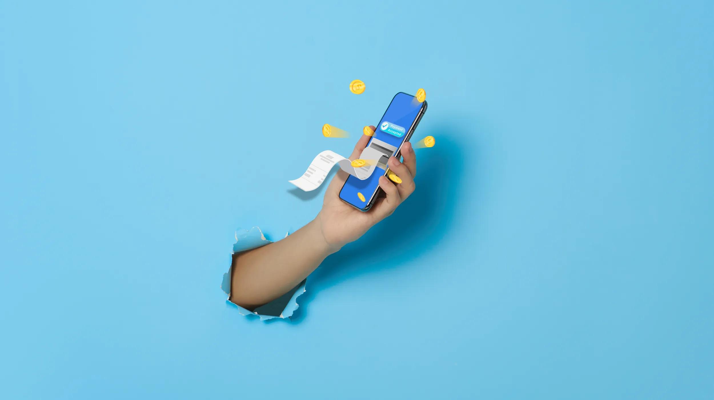 A hand emerges through a tear in a blue background, holding a smartphone displaying a payment confirmation screen. Coins and a receipt are popping out from the phone, symbolizing a digital transaction.