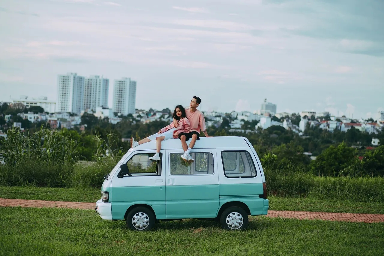 A Couple Sits atop Their Van