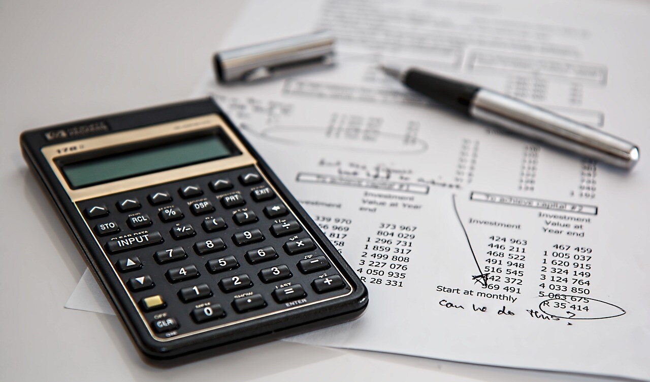 a calculator and a pen on a piece of paper