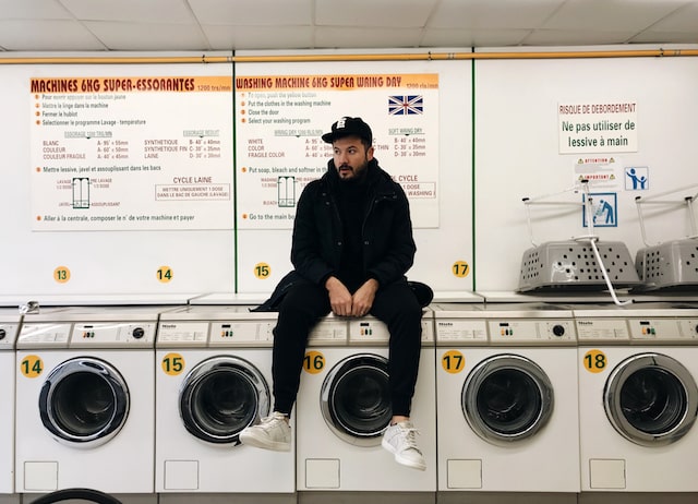 SYML Brian Fennell Sitting on Washing Machine in Laundromat