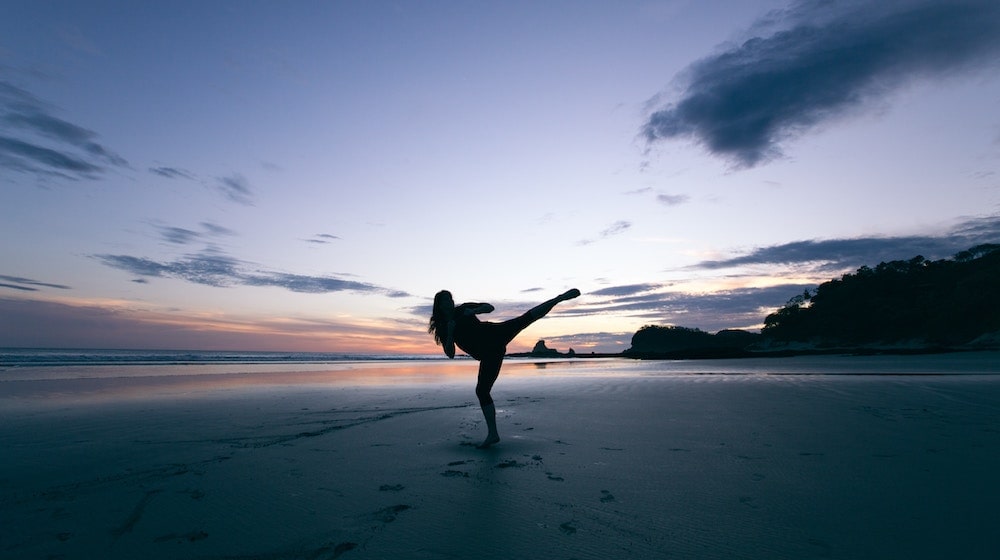 What Is Imposter Syndrome Woman kicking on beach